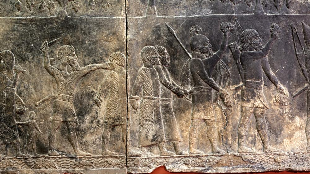 Relieve asirio del palacio de Senaquerib con prisioneros encadenados y un cautivo ejecutado durante la marcha.